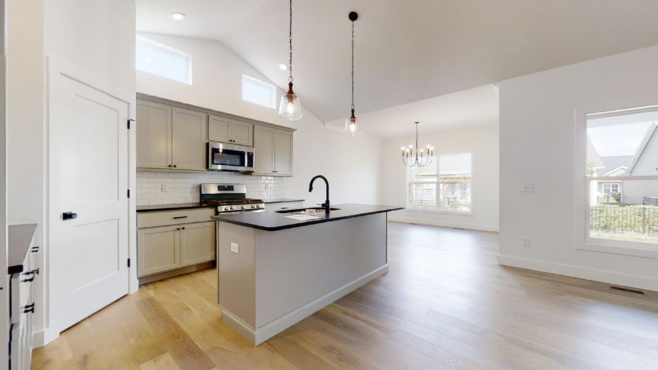 3910 Bay Circle Champaign, IL 61822 - Photo 9 of 49 a kitchen with stainless steel appliances granite countertop a sink a stove and a wooden floor