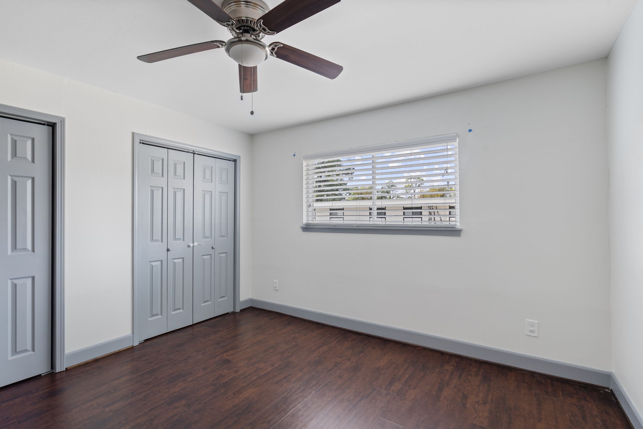 1271 Witte Road, Unit 26 Houston, TX 77055 - Photo 23 of 27 an empty room with wooden floor chandelier fan and windows