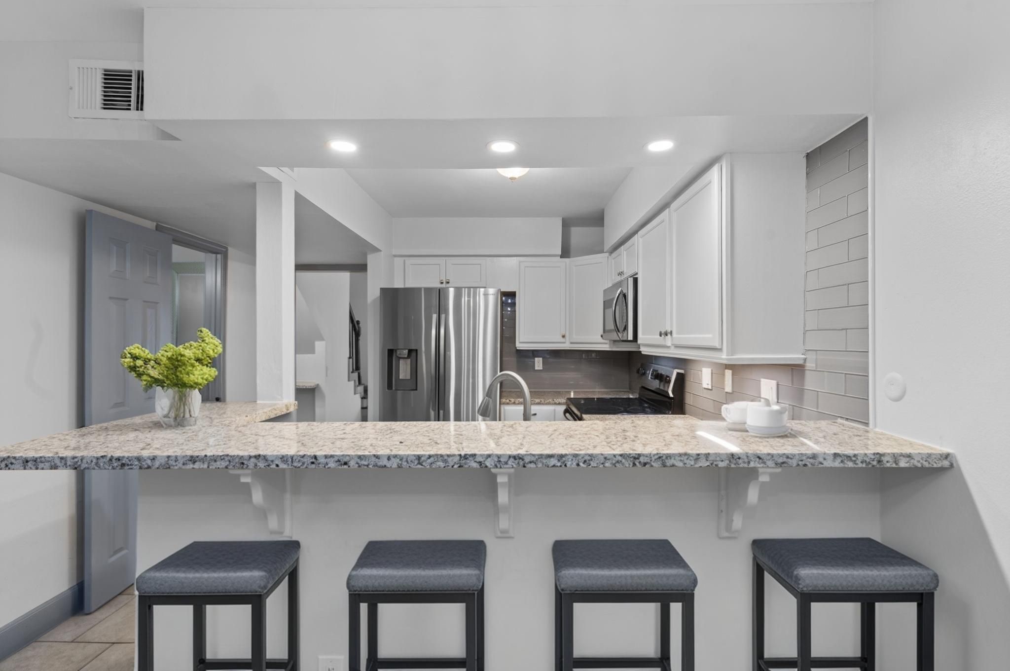 1271 Witte Road, Unit 26 Houston, TX 77055 - Photo 9 of 27 a kitchen with center island and a wooden cabinets