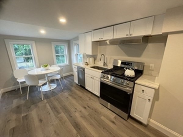 613 Grove Street, Unit 1 Newton, MA 02462 - Photo 1 of 13 a kitchen with a stove a sink and a refrigerator