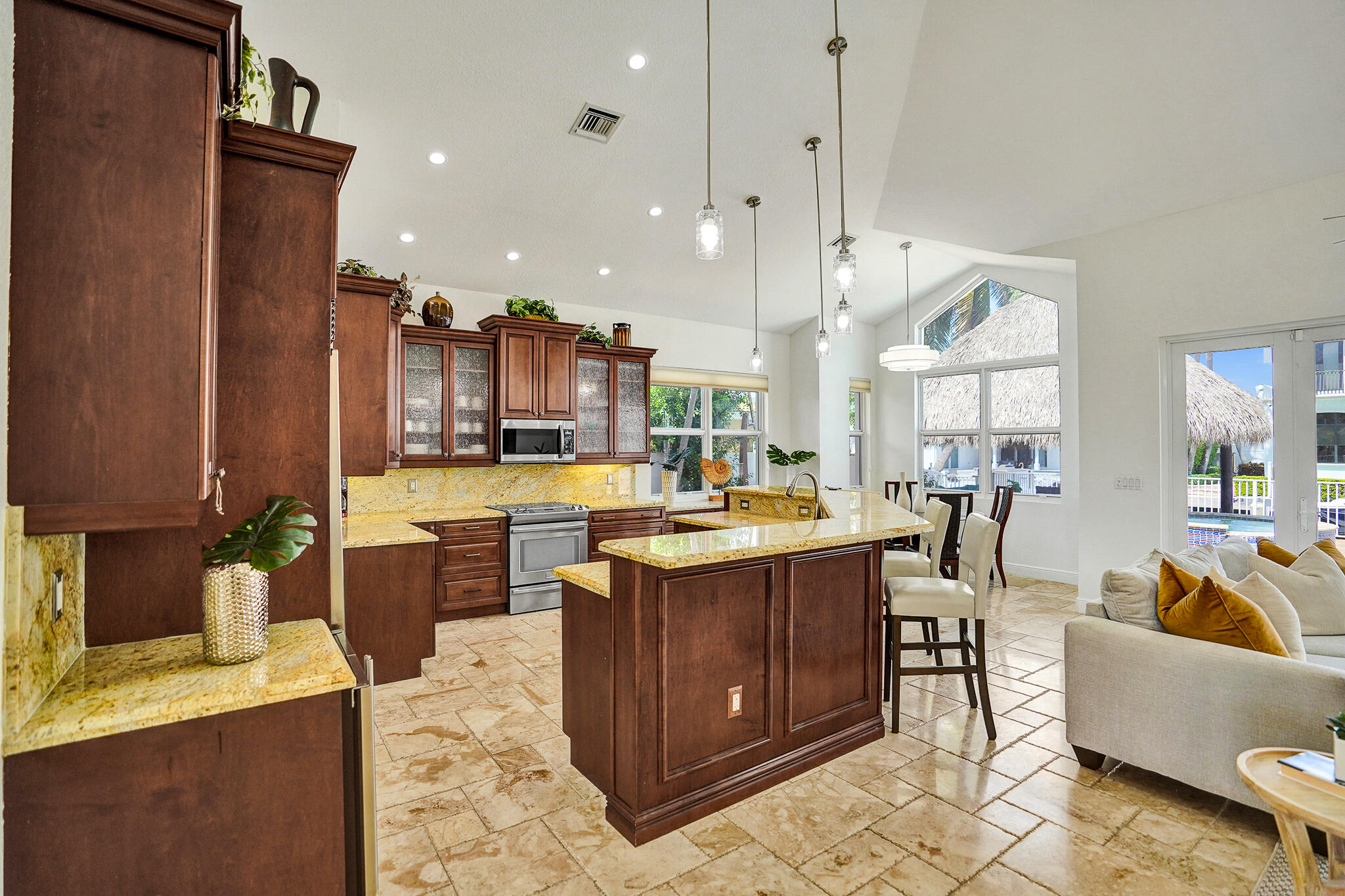 785 Northeast 71st Street Boca Raton, FL 33487 - Photo 18 of 62 a view of a kitchen with kitchen island granite countertop a sink a counter top space and living room view