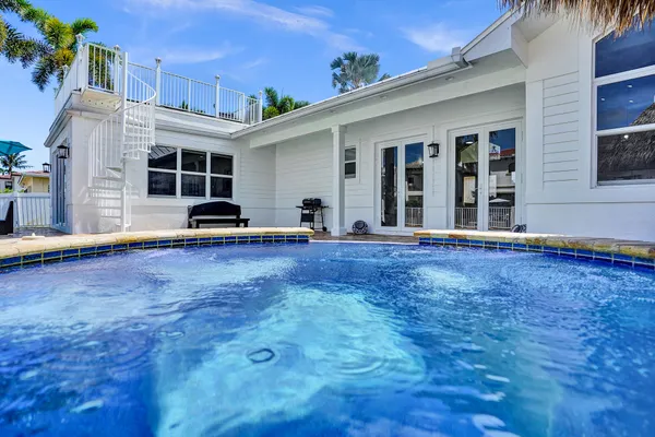 a swimming pool with outdoor seating and a garden