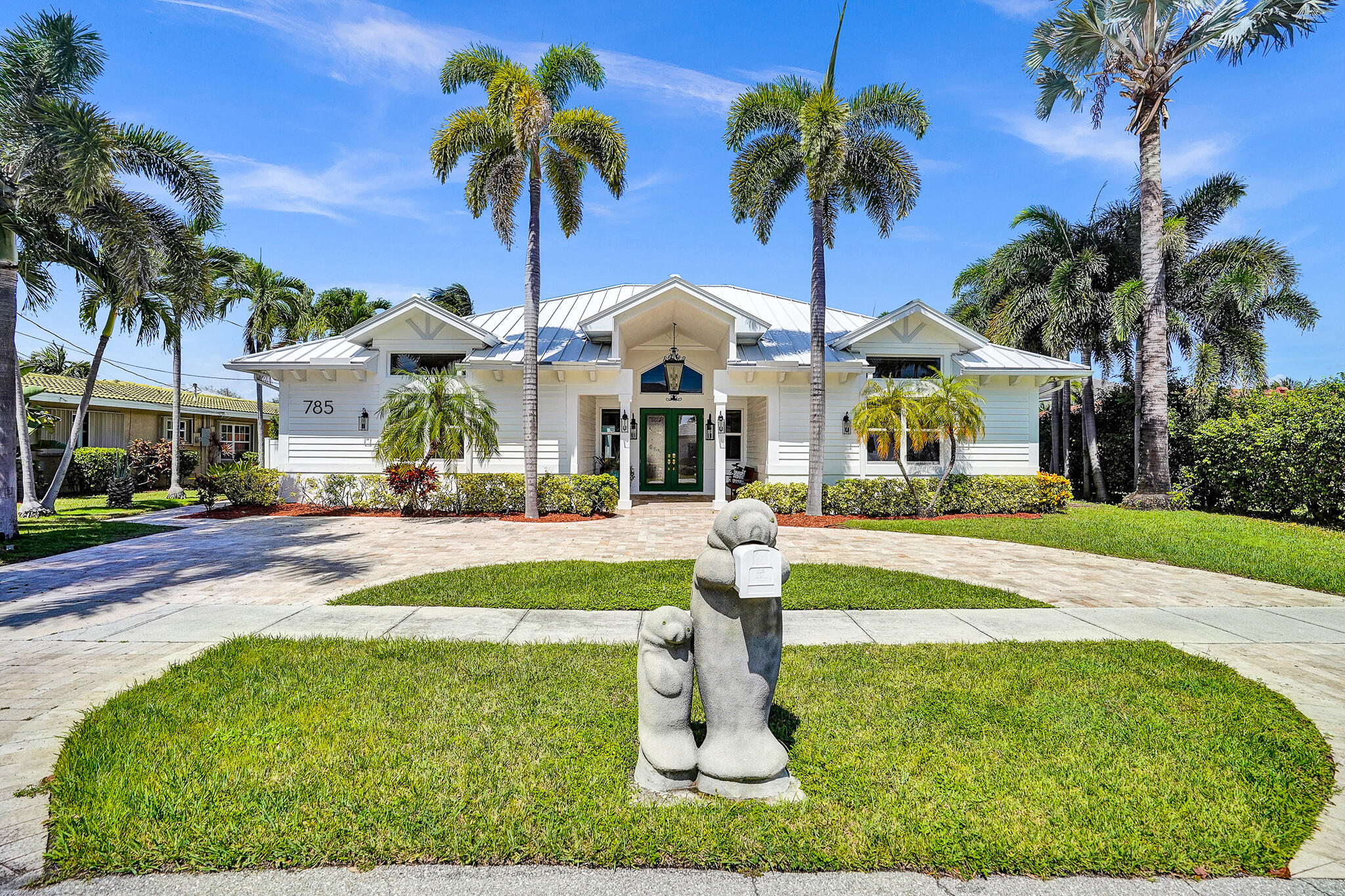 785 Northeast 71st Street Boca Raton, FL 33487 - Photo 60 of 62 a front view of yellow house with swimming pool and palm tree
