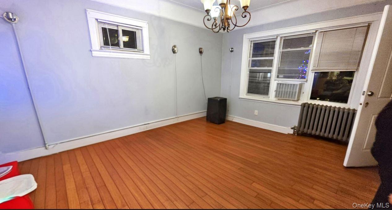 25-55 97th Street Queens, NY 11369 - Photo 2 of 15 a view of an empty room with a window and wooden floor