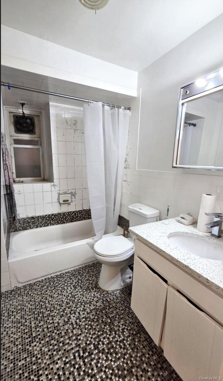 25-55 97th Street Queens, NY 11369 - Photo 5 of 15 a bathroom with a granite countertop sink toilet a mirror and shower