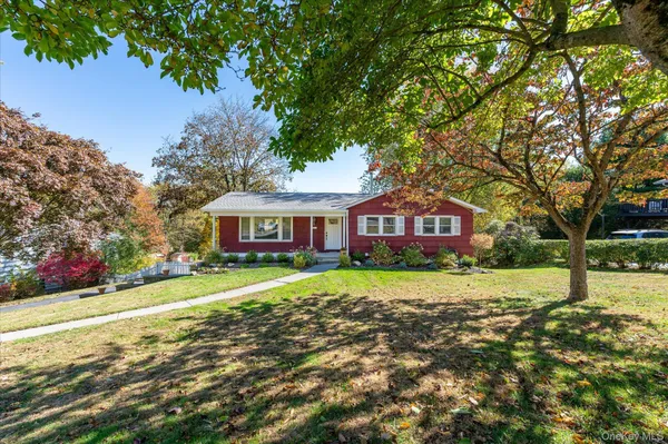 a view of a big yard next to a house with large trees