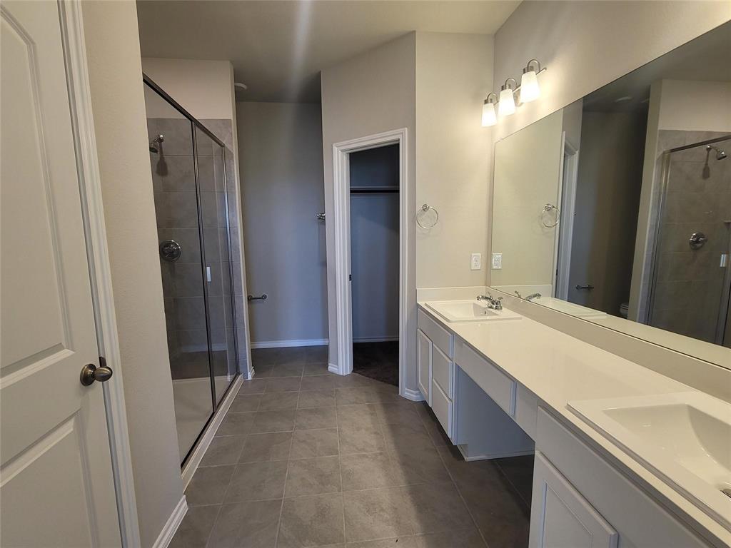 933 Ravenwood Lane Van Alstyne, TX 75495 - Photo 4 of 10 a bathroom with a double vanity sink and mirror
