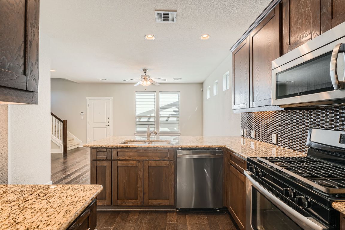 12200 Barras Branch Drive, Unit 135 Austin, TX 78748 - Photo 11 of 31 a kitchen with stainless steel appliances granite countertop a sink and a stove