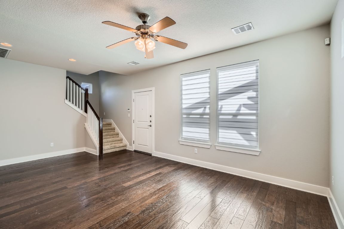 12200 Barras Branch Drive, Unit 135 Austin, TX 78748 - Photo 7 of 31 a view of an empty room with wooden floor and a window