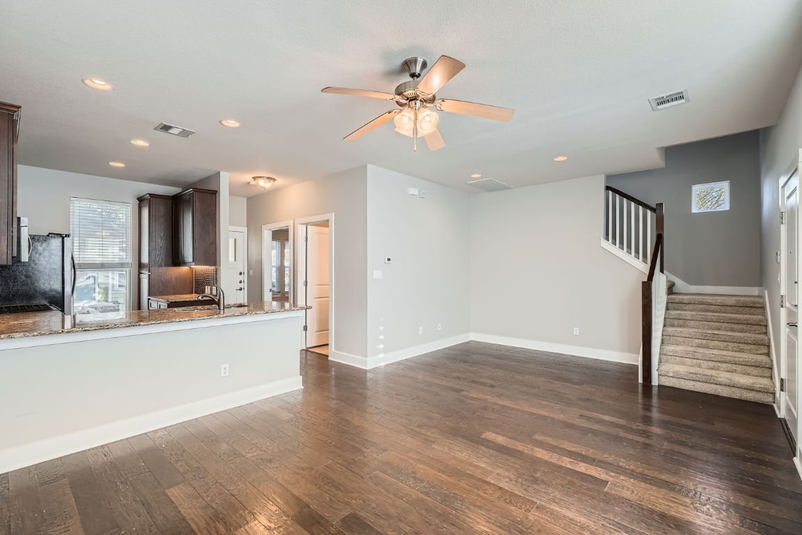 12200 Barras Branch Drive, Unit 135 Austin, TX 78748 - Photo 8 of 31 a view of a kitchen with a sink a refrigerator a ceiling fan and wooden floor