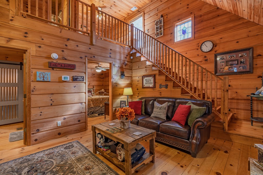 659 Kells Ridge Drive Ellijay, GA 30540 - Photo 29 of 41 a living room with furniture a ceiling fan and a wooden floor