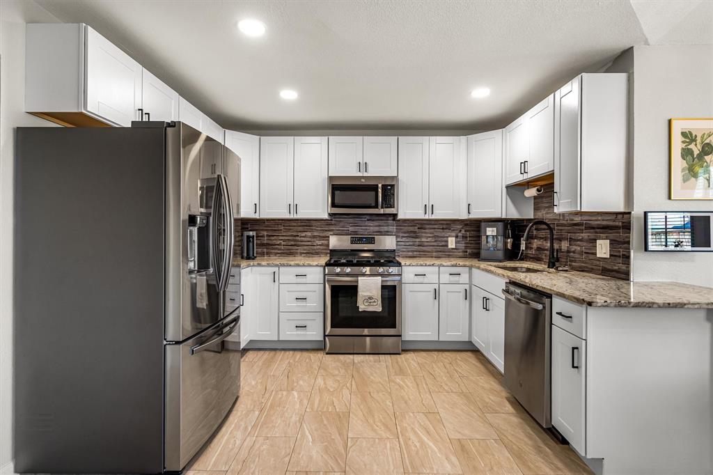 2113 Garner Court Rowlett, TX 75088 - Photo 14 of 40 a kitchen with granite countertop a refrigerator stove top oven and sink