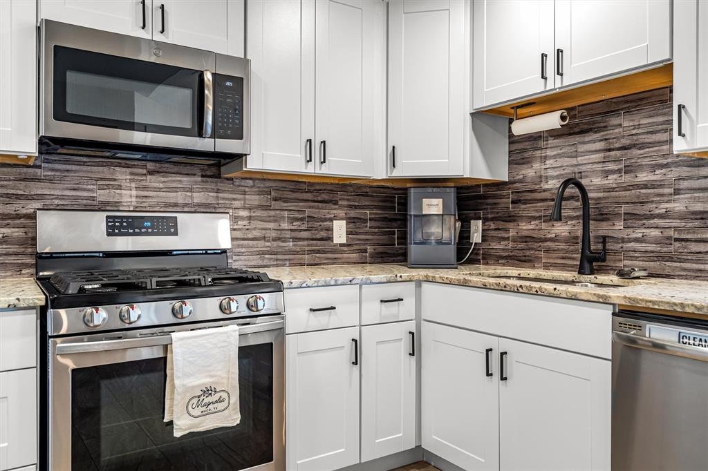 2113 Garner Court Rowlett, TX 75088 - Photo 15 of 40 a kitchen with granite countertop cabinets stainless steel appliances and a sink