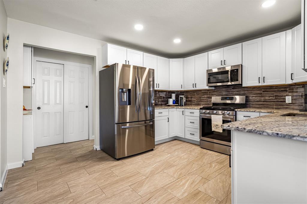 2113 Garner Court Rowlett, TX 75088 - Photo 16 of 40 a kitchen with stainless steel appliances granite countertop a refrigerator stove a sink and a microwave