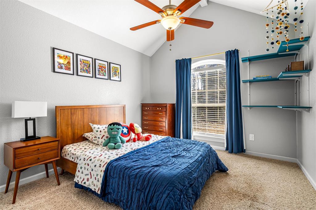 2113 Garner Court Rowlett, TX 75088 - Photo 23 of 40 a bedroom with a bed and a chandelier