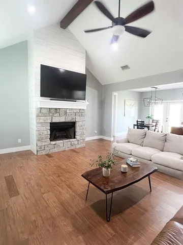 a living room with furniture a flat screen tv and a fireplace