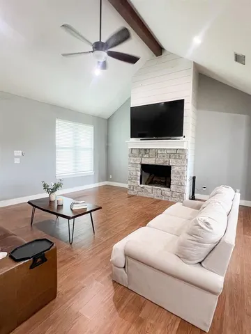a living room with furniture a flat screen tv and a fireplace