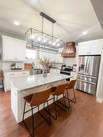 a kitchen with granite countertop a table chairs stove and cabinets
