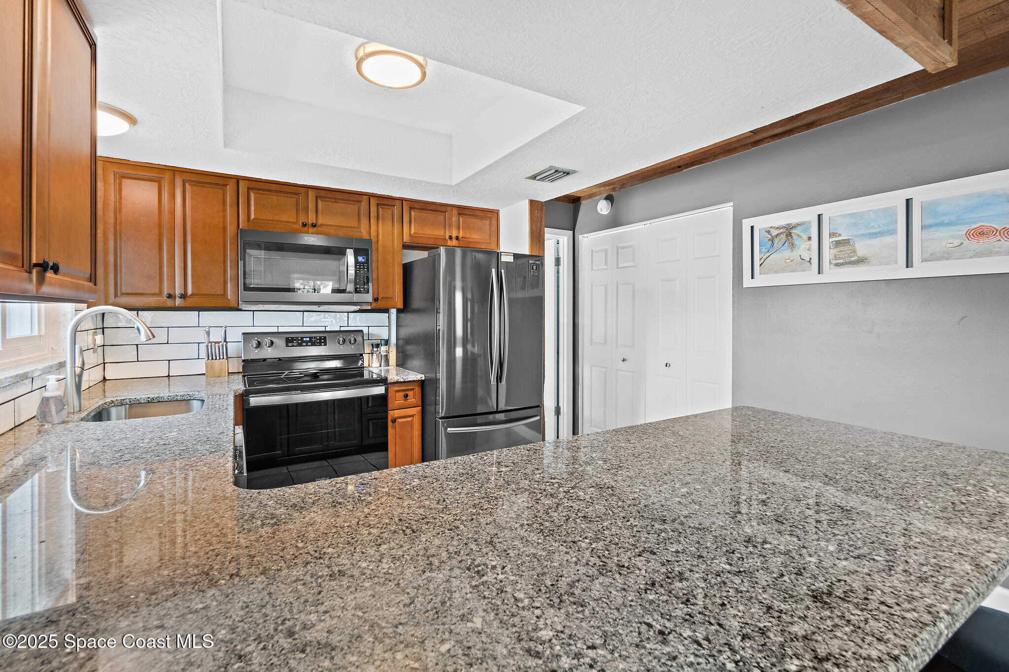 8156 Ridgewood Avenue Cape Canaveral, FL 32920 - Photo 24 of 53 a kitchen with stainless steel appliances a refrigerator stove and sink