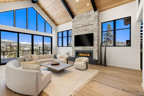 a living room with furniture a flat screen tv and a floor to ceiling window
