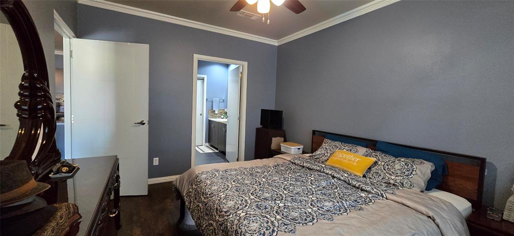 1100 West Trinity Mills Road, Unit 2045 Carrollton, TX 75006 - Photo 5 of 20 Bedroom with crown molding, dark wood-style flooring, ceiling fan, and connected bathroom