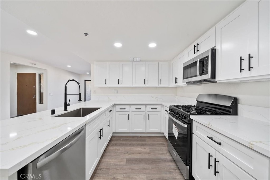 200 East Racquet Club Road, Unit 72 Palm Springs, CA 92262 - Photo 6 of 19 a kitchen with granite countertop white cabinets and stainless steel appliances