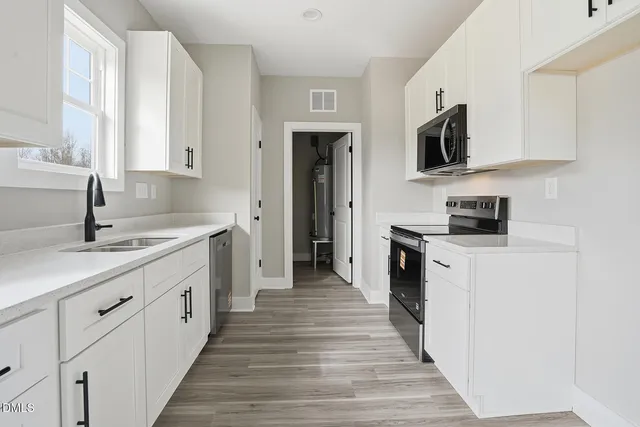 a kitchen with stainless steel appliances granite countertop a sink and dishwasher a stove top oven with wooden floor