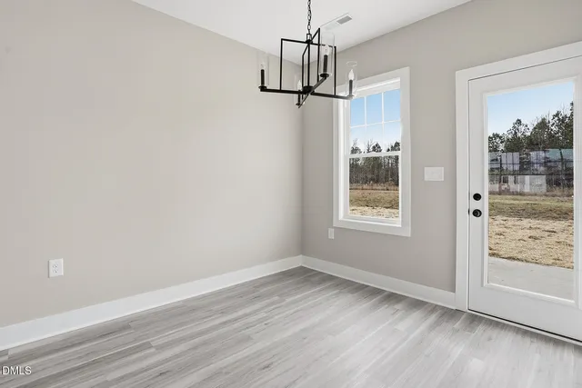 a view of a room with wooden floor windows and chandelier