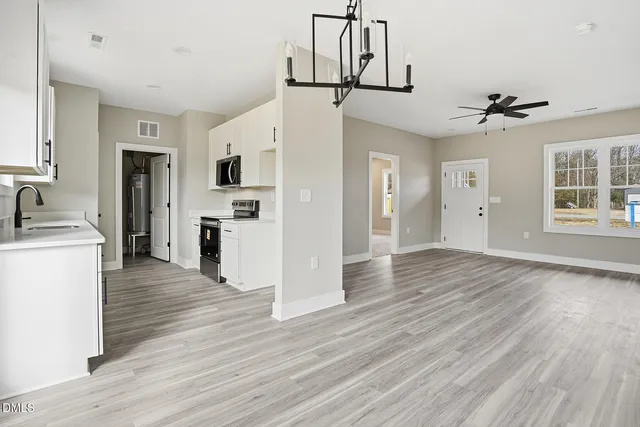 a view of a kitchen with a refrigerator a microwave oven a sink dishwasher and a refrigerator with wooden floor