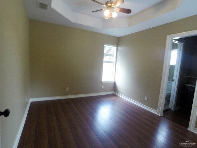 204 San Saba Street Mission, TX 78572 - Photo 11 of 15 an empty room with wooden floor and windows