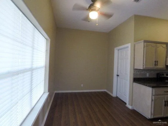 a view of a kitchen with a fridge and wooden floor