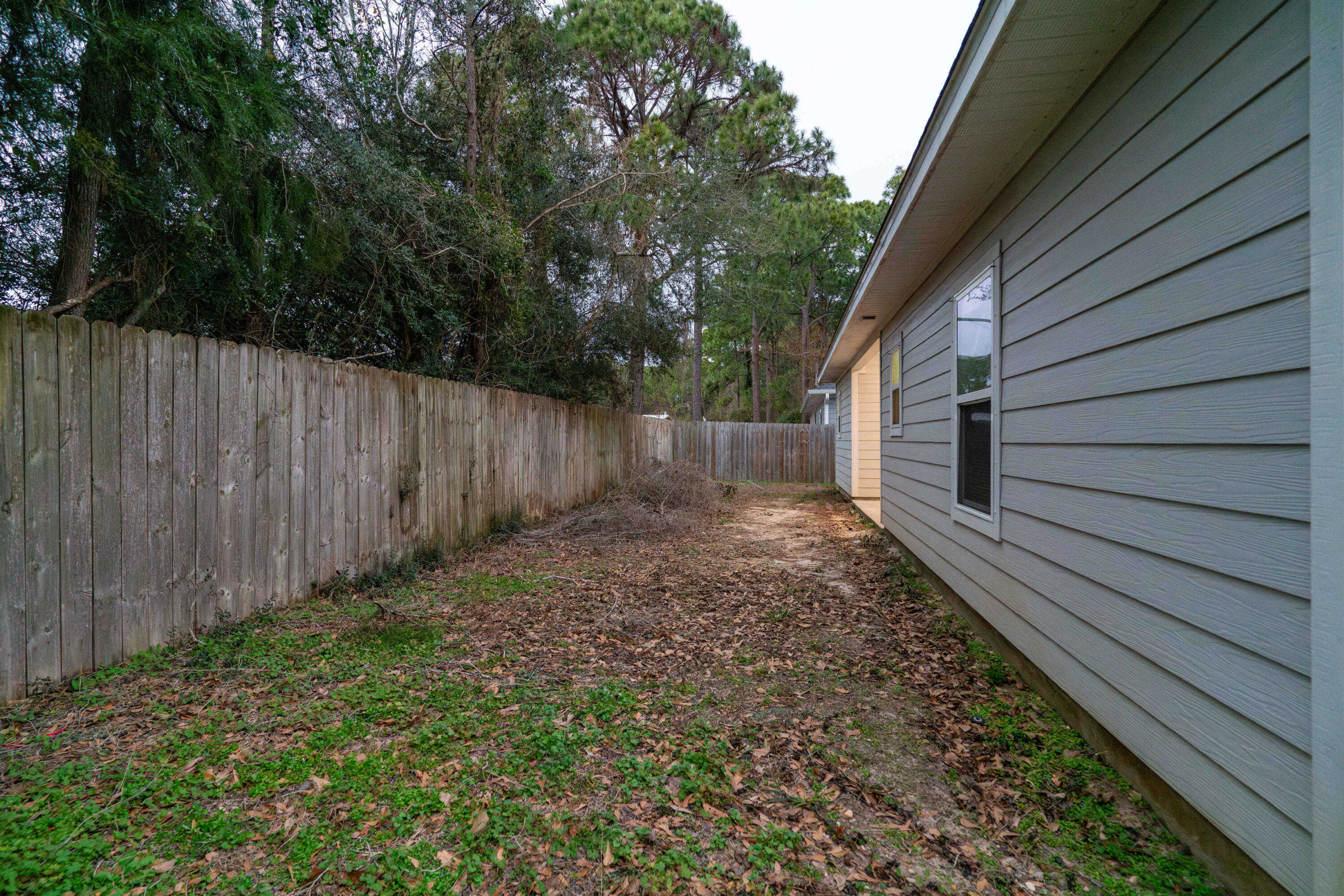 2243 Wind Trace Road North Navarre, FL 32566 - Photo 32 of 34 a view of a backyard with wooden fence