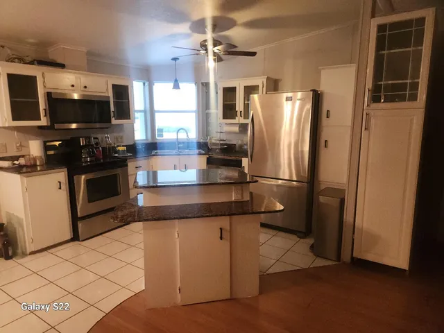 a kitchen with stainless steel appliances a refrigerator sink and microwave
