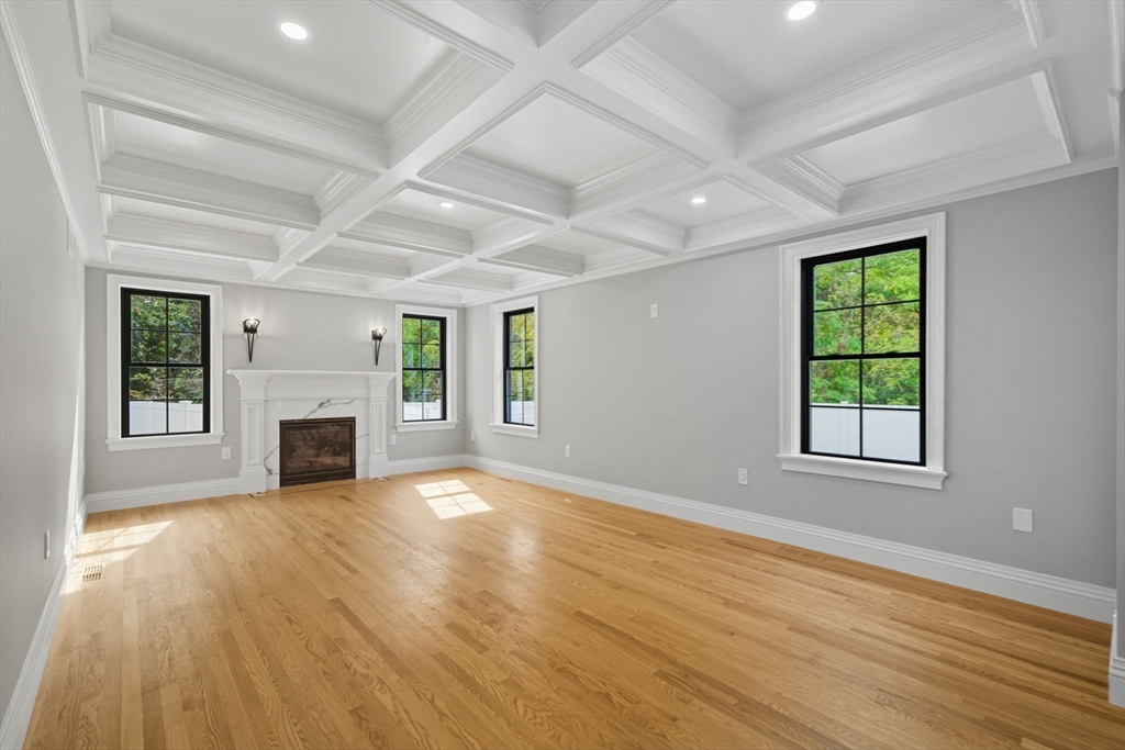 185 Lexington Street Woburn, MA 01801 - Photo 11 of 39 an empty room with windows fireplace and wooden floor