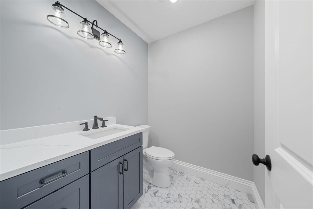 185 Lexington Street Woburn, MA 01801 - Photo 17 of 39 a bathroom with a toilet a sink a vanity and mirror