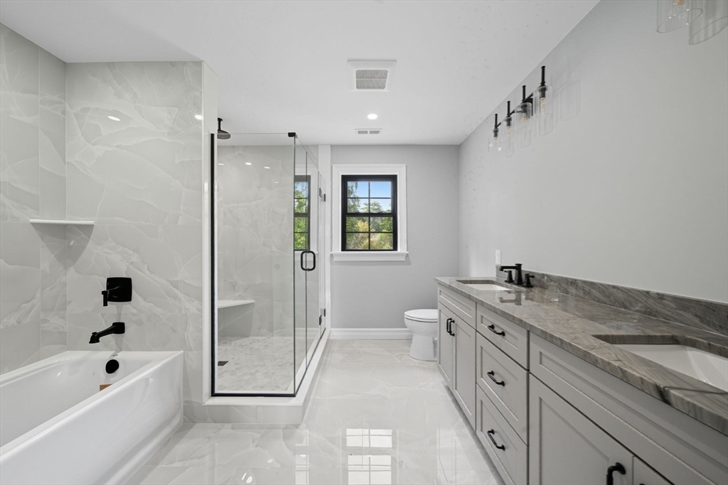185 Lexington Street Woburn, MA 01801 - Photo 19 of 39 a spacious bathroom with a granite countertop sink a toilet a mirror and shower
