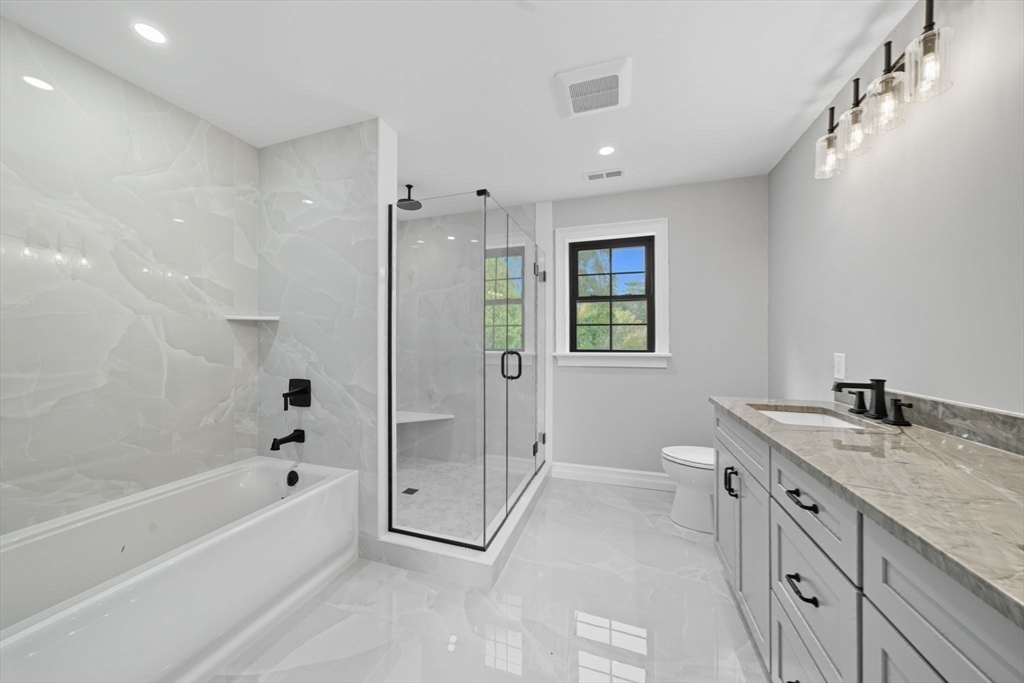 185 Lexington Street Woburn, MA 01801 - Photo 20 of 39 a spacious bathroom with a granite countertop sink a toilet and shower