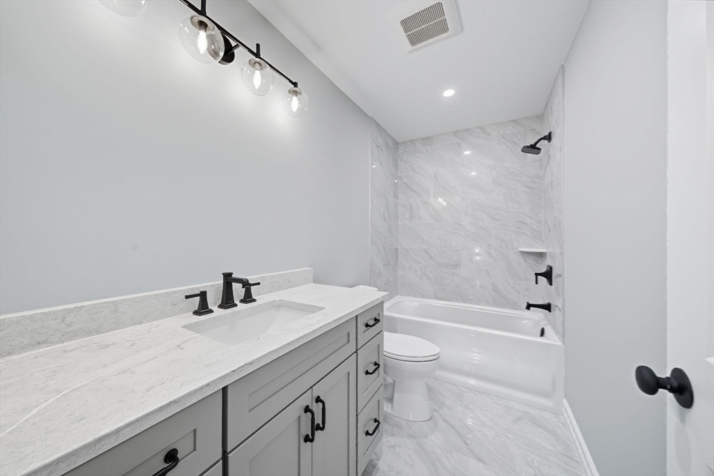 185 Lexington Street Woburn, MA 01801 - Photo 26 of 39 a bathroom with a granite countertop sink a toilet and shower