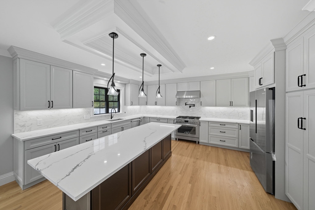 185 Lexington Street Woburn, MA 01801 - Photo 5 of 39 a large kitchen with kitchen island a sink a stove and a refrigerator