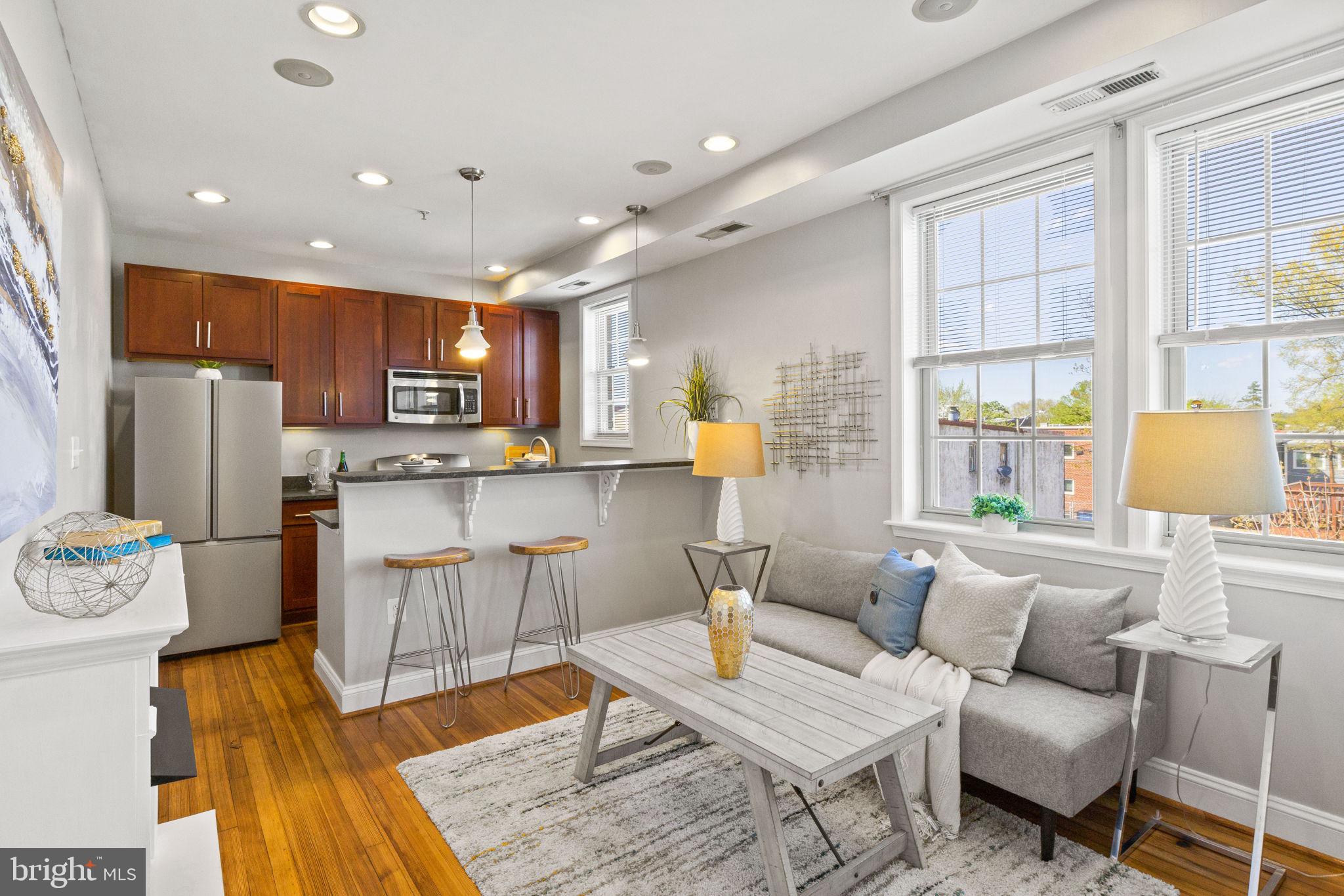 410 15th Street Northeast, Unit 22 Washington, DC 20002 - Photo 1 of 27 a living room with stainless steel appliances kitchen island granite countertop furniture and a wooden floor