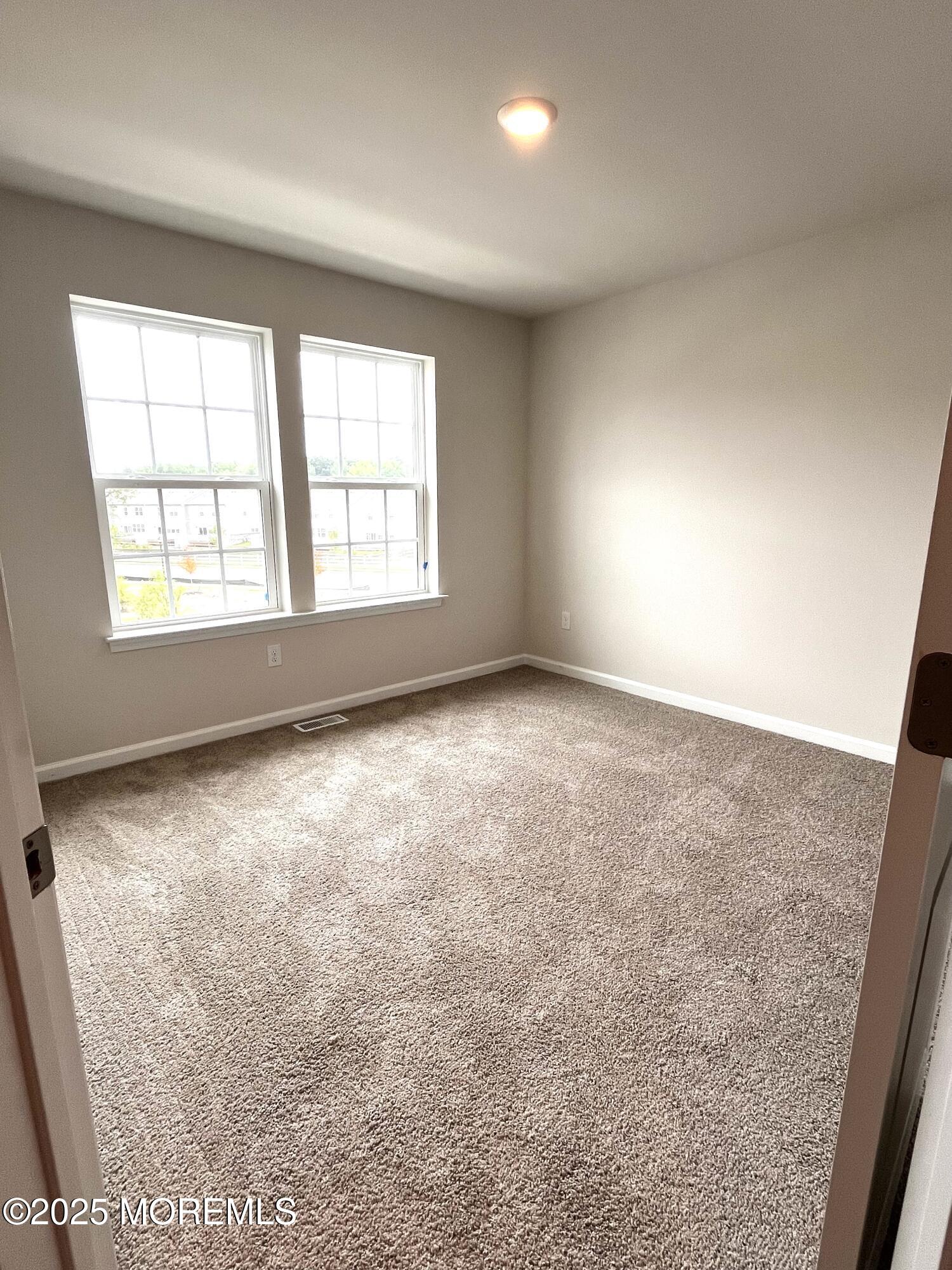 16 Rothbury Court Tinton Falls, NJ 07753 - Photo 19 of 28 an empty room with a empty space and windows
