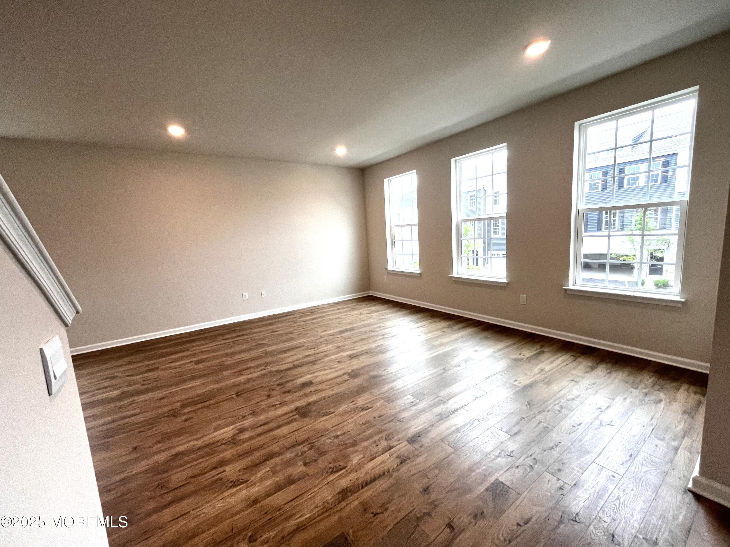 16 Rothbury Court Tinton Falls, NJ 07753 - Photo 5 of 28 an empty room with wooden floor and windows
