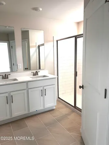a spacious bathroom with a double vanity sink and a mirror