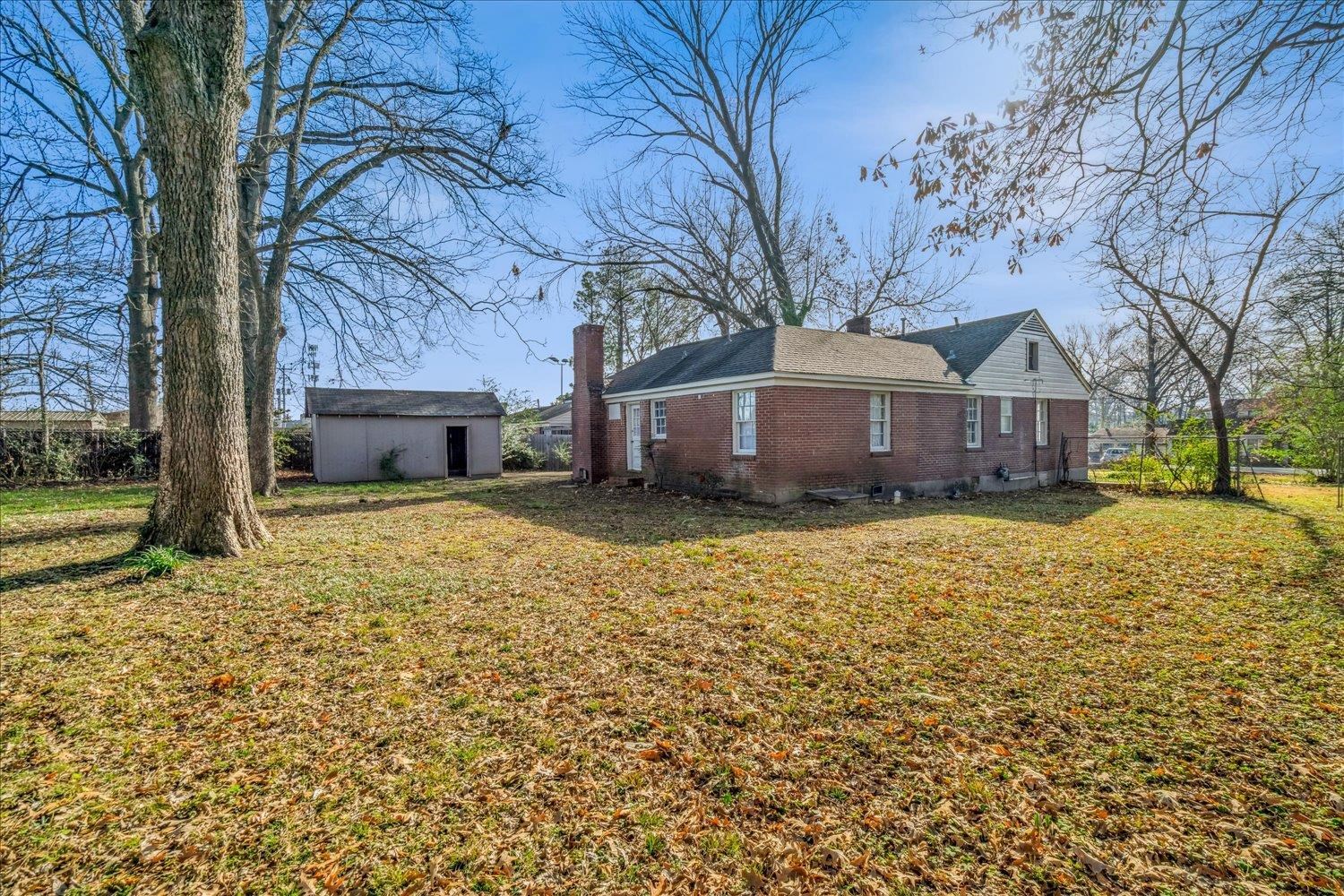 1114 Brownlee Road Memphis, TN 38116 - Photo 31 of 32 a front view of a house with a yard covered with snow and trees