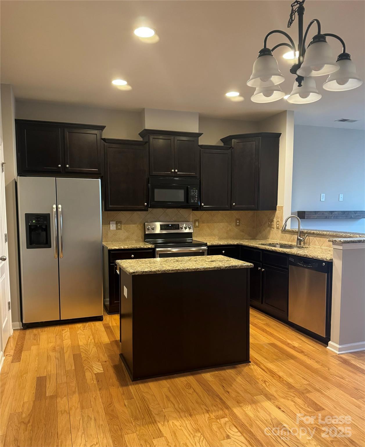 18431 The Commons Boulevard Cornelius, NC 28031 - Photo 2 of 24 a kitchen with stainless steel appliances granite countertop a stove a refrigerator and a sink