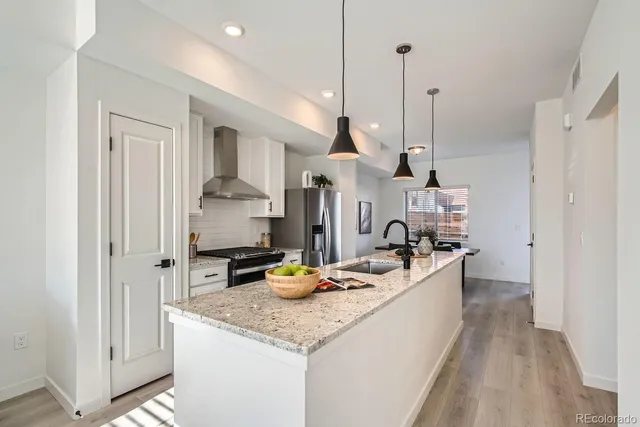 a kitchen with a sink a counter top space and stainless steel appliances