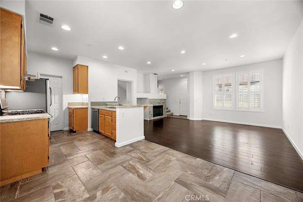 748 Ashby Lane, Unit 55 Brea, CA 92821 - Photo 13 of 41 a view of a kitchen with kitchen island a sink wooden floor and a refrigerator