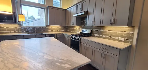 a kitchen with stainless steel appliances granite countertop a sink stove and microwave