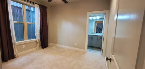 a view of an empty room with closet and a window