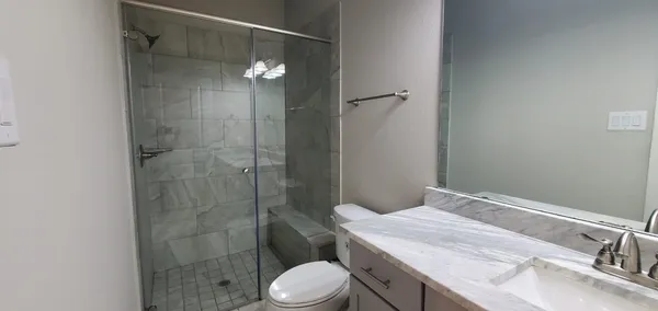 a bathroom with a sink a toilet and shower